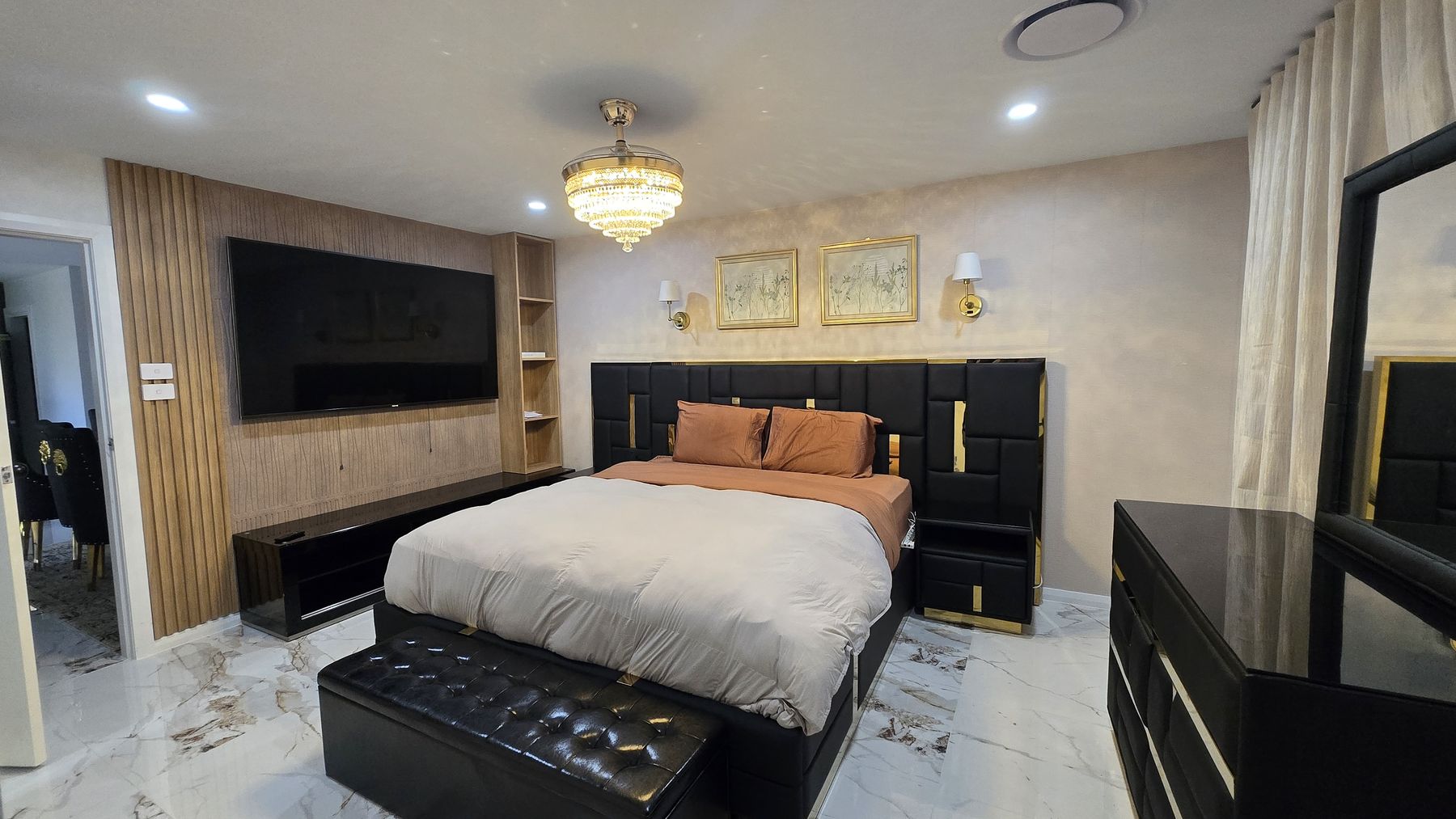 Noir primary suite with crystal chandelier