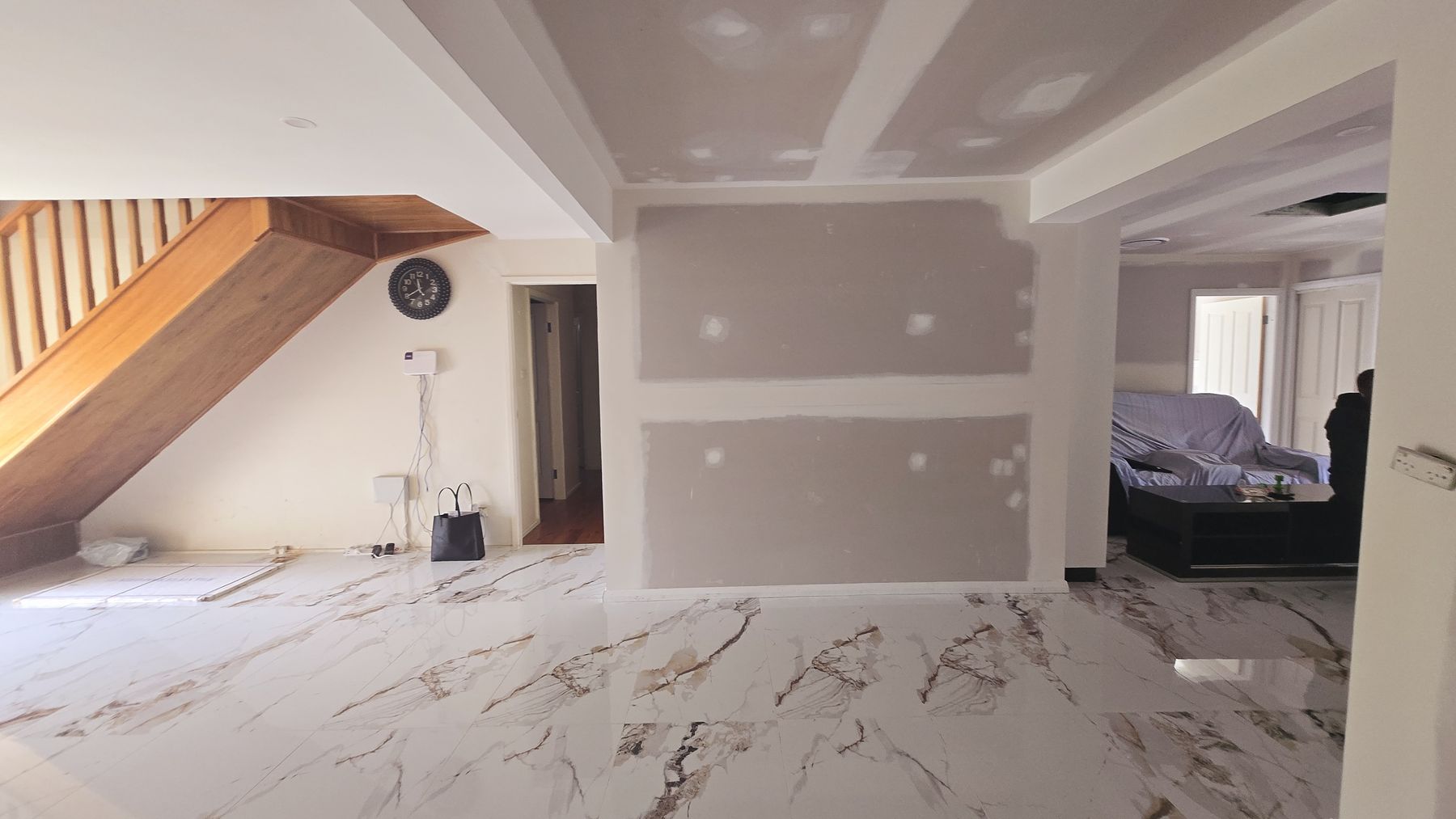 Before — the staircase zone at drywall stage, boxes and bare plaster